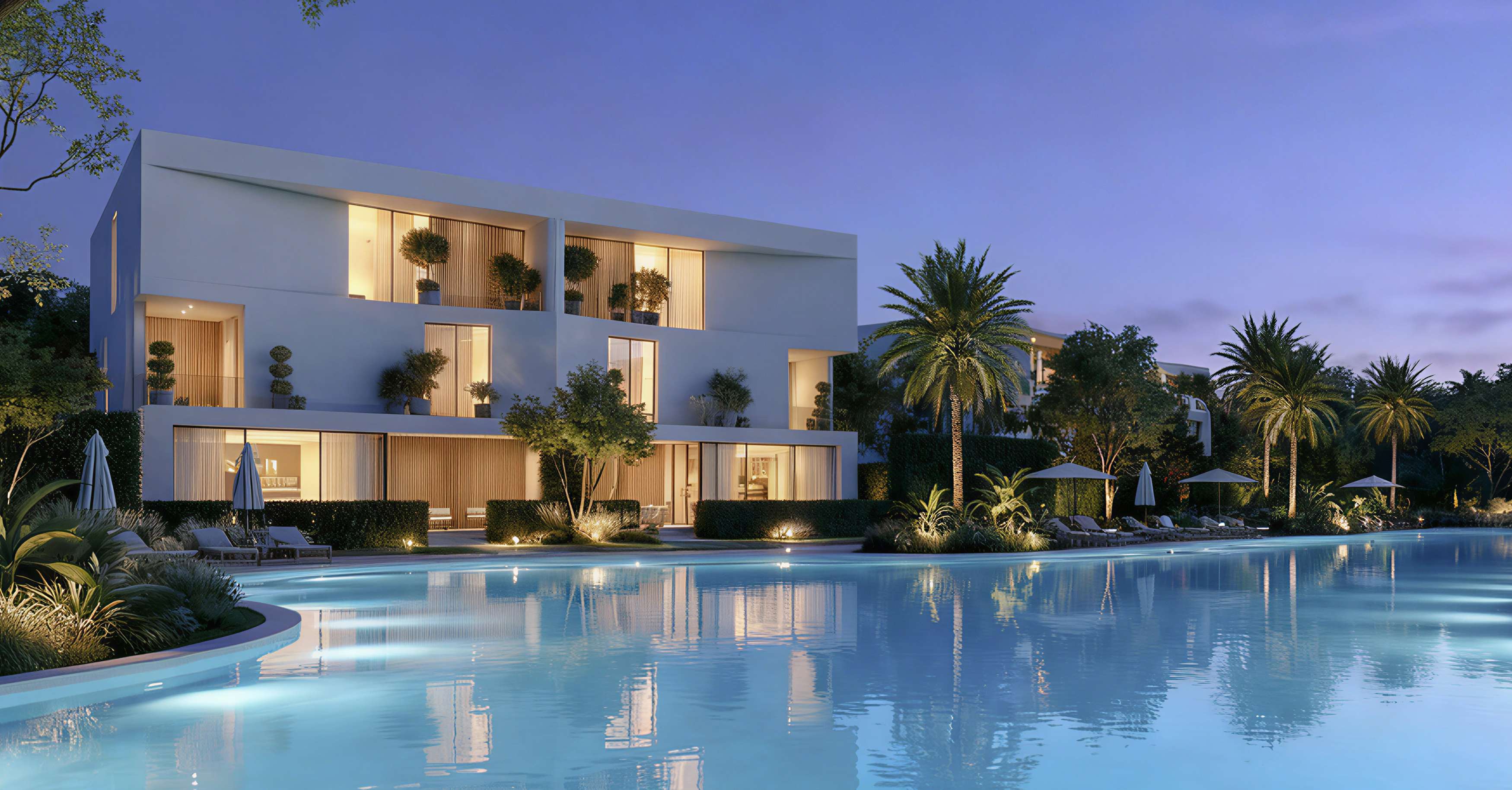 White Dune villas lit at dusk beside a wide lagoon lined with palms